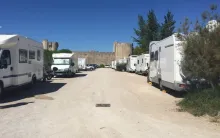 Vue panoramique du Parking P4 – Aire de services et de repos à Aigues-Mortes, dans le Gard, avec espaces pour camping-cars et voitures, vidange et approvisionnement en eau pour voyageurs.